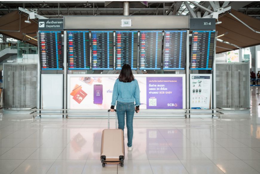 A passenger looking at an airport departure board 